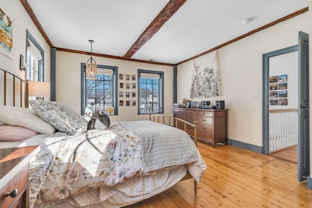 bedroom with crown molding, light wood-type flooring, and baseboards