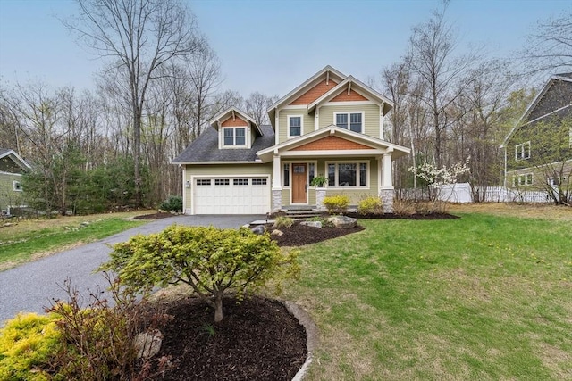 craftsman inspired home featuring a garage, a front lawn, fence, and driveway
