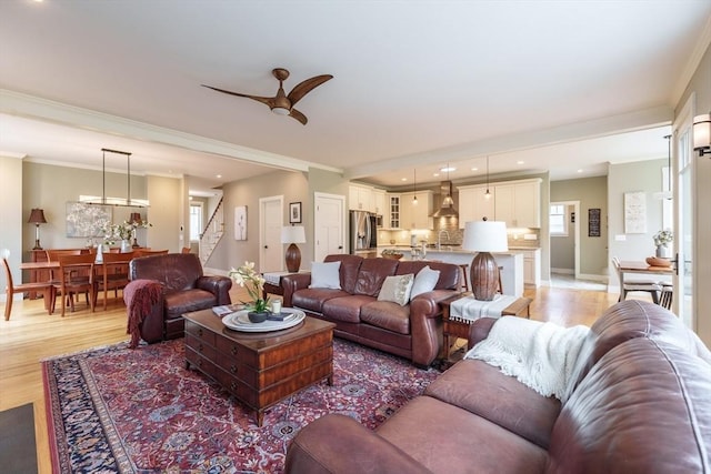 living area featuring ornamental molding, stairway, light wood-type flooring, recessed lighting, and a ceiling fan