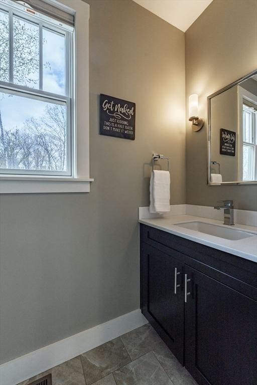 bathroom featuring baseboards, tile patterned flooring, and vanity