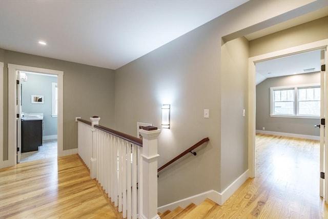 hallway featuring recessed lighting, baseboards, an upstairs landing, and light wood-type flooring
