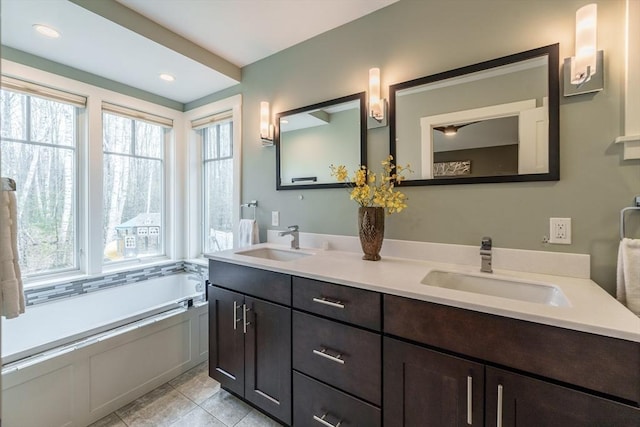 bathroom with a garden tub, a sink, and double vanity