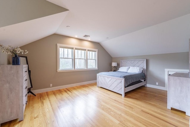 bedroom featuring light wood-style floors, baseboards, lofted ceiling, and visible vents