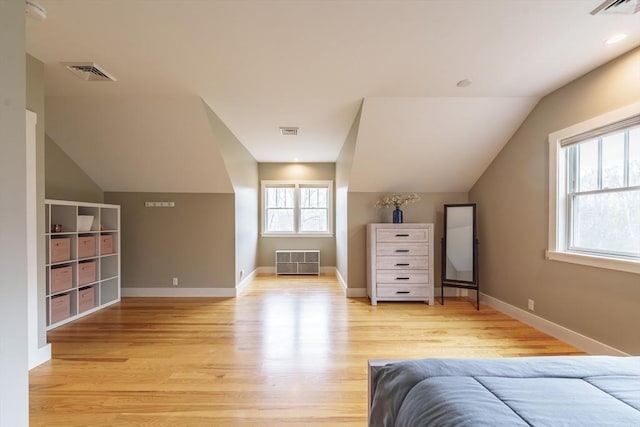 bedroom featuring lofted ceiling, light wood finished floors, and visible vents