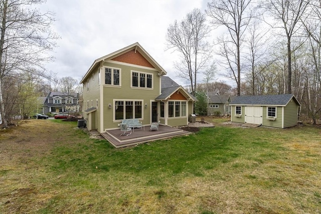 back of property featuring a lawn, an outbuilding, a wooden deck, and central AC unit