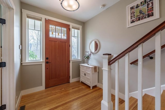 foyer featuring stairs, baseboards, visible vents, and light wood-style floors