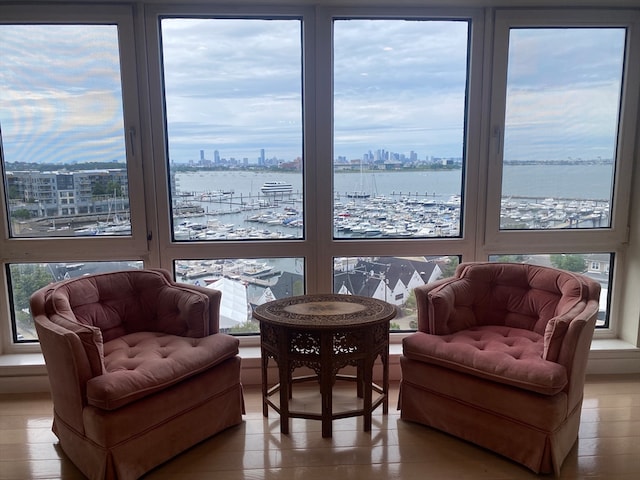 sitting room with hardwood / wood-style flooring and a water view