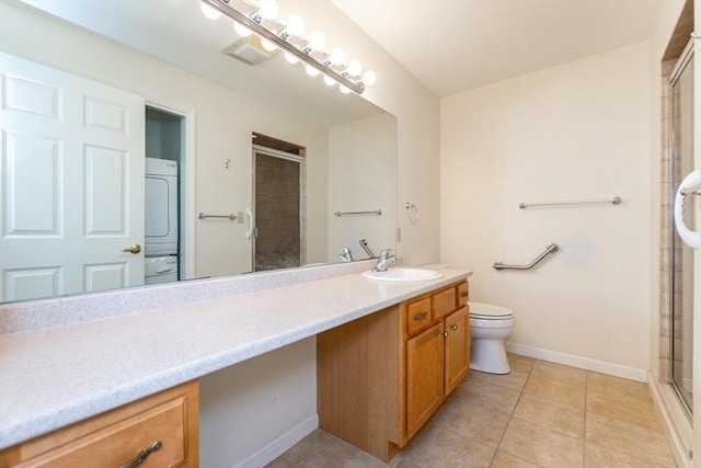 bathroom featuring tile patterned floors, vanity, a shower with shower door, and toilet