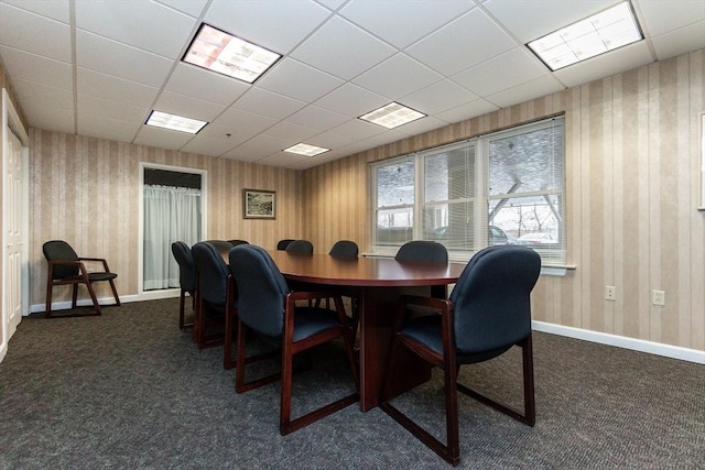 carpeted dining area with a drop ceiling