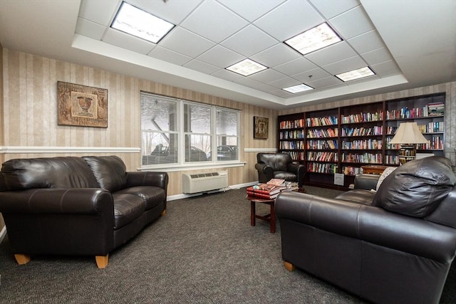 interior space with a wall unit AC, a raised ceiling, and a paneled ceiling