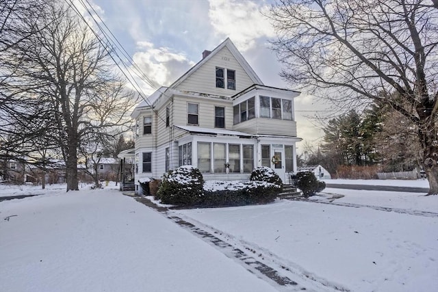 snow covered property with a sunroom