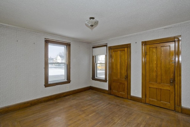 unfurnished bedroom featuring ornamental molding, hardwood / wood-style floors, and a textured ceiling