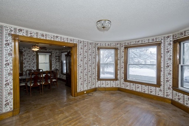 unfurnished dining area with dark hardwood / wood-style flooring and a textured ceiling