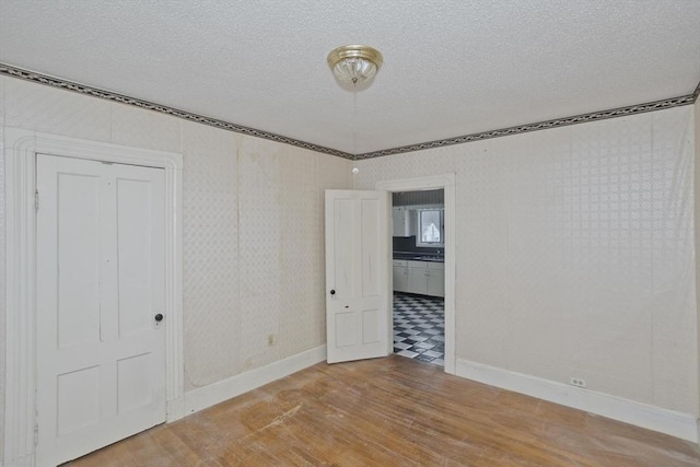 unfurnished bedroom featuring wood-type flooring and a textured ceiling