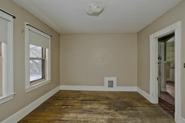 empty room with dark hardwood / wood-style flooring