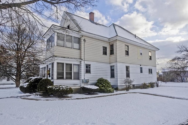 view of snow covered rear of property