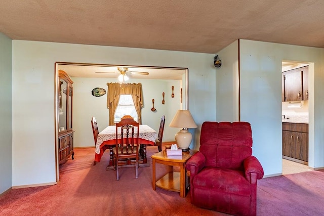 carpeted dining space featuring ceiling fan and a textured ceiling