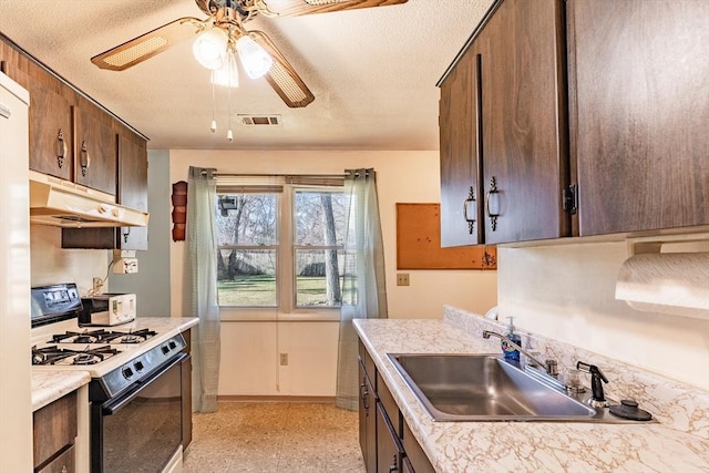 kitchen with dark brown cabinetry, ceiling fan, gas range gas stove, and sink