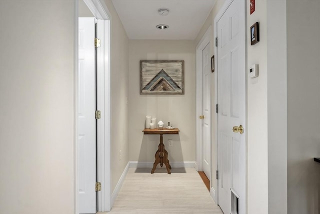 corridor featuring light wood-style floors and baseboards