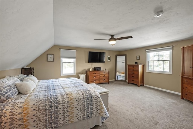 bedroom with light carpet, baseboards, ceiling fan, and lofted ceiling