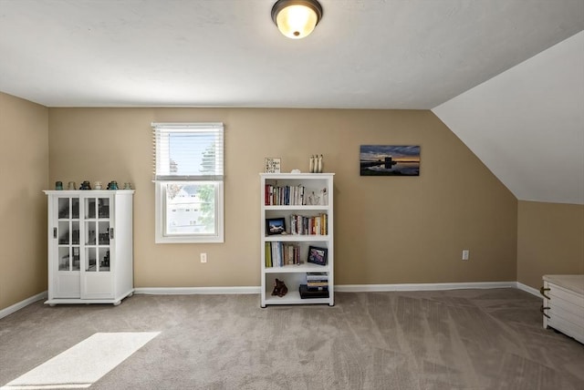 living area with carpet, baseboards, and lofted ceiling