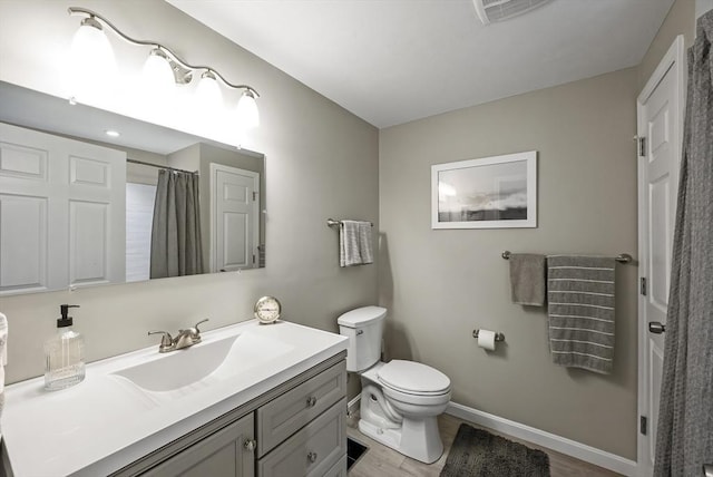 bathroom with toilet, baseboards, vanity, curtained shower, and wood finished floors