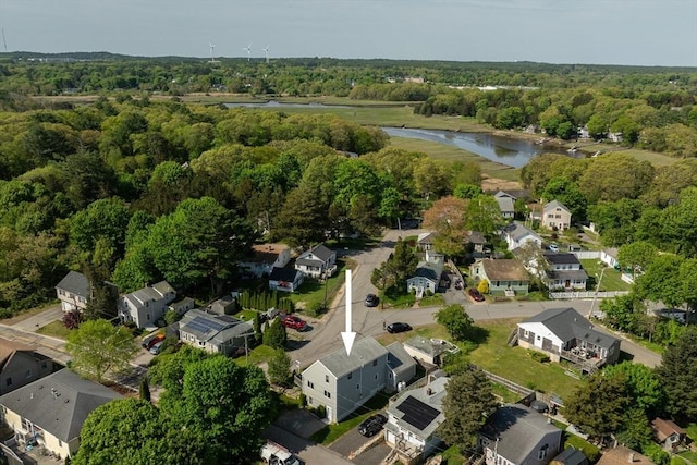 aerial view of property's location with a large body of water, a heavily wooded area, and nearby suburban area