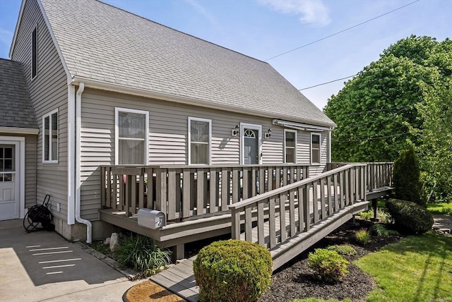 back of property featuring a wooden deck and a shingled roof