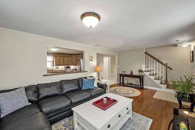 living area with stairs and wood finished floors