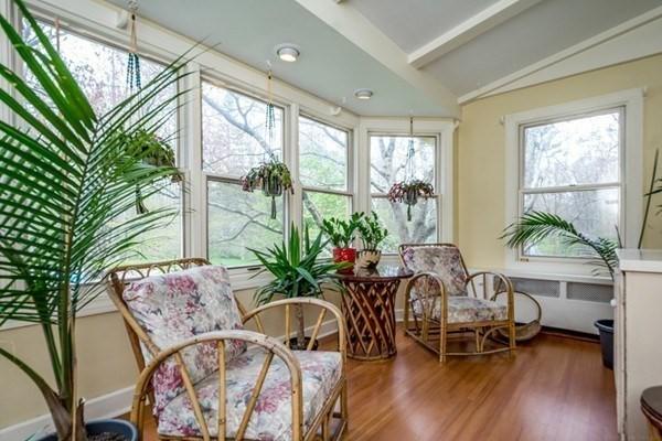 sunroom featuring wood finished floors and lofted ceiling with beams