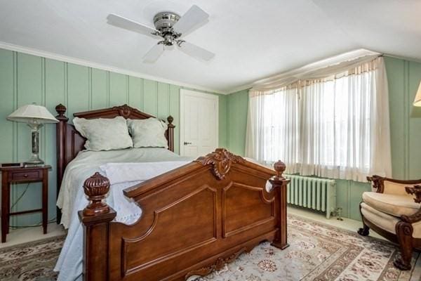 bedroom with ornamental molding, radiator heating unit, a ceiling fan, and vaulted ceiling