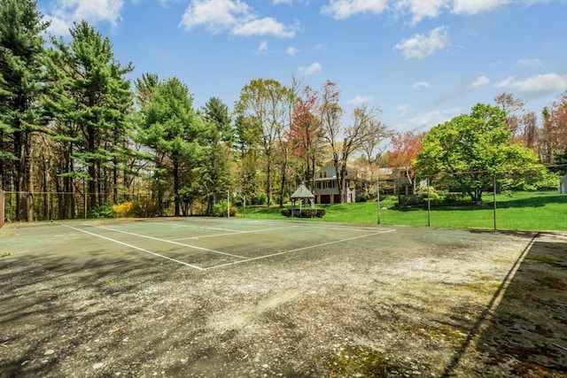 view of tennis court featuring community basketball court and a yard