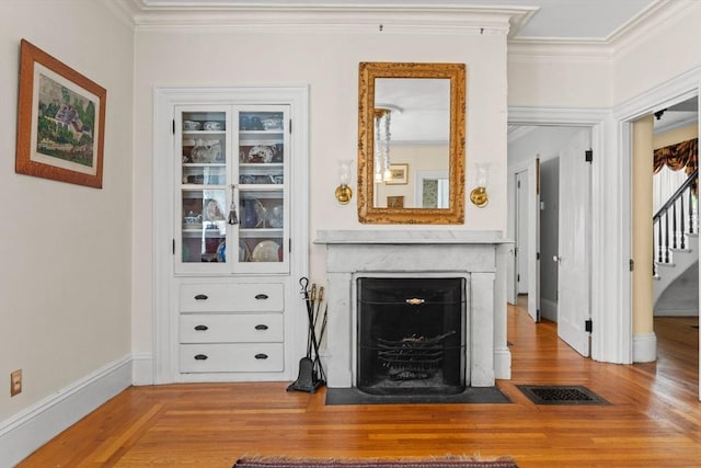31 Boylston St, Boston, MA 02130 - living room featuring ornamental molding, wood finished floors, a fireplace with flush hearth, stairs, and baseboards