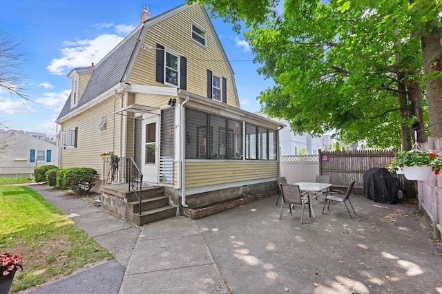 8A 3rd St, Medford, MA 02155 - back of house featuring a gambrel roof, a patio, a sunroom, outdoor dining space, and roof with shingles