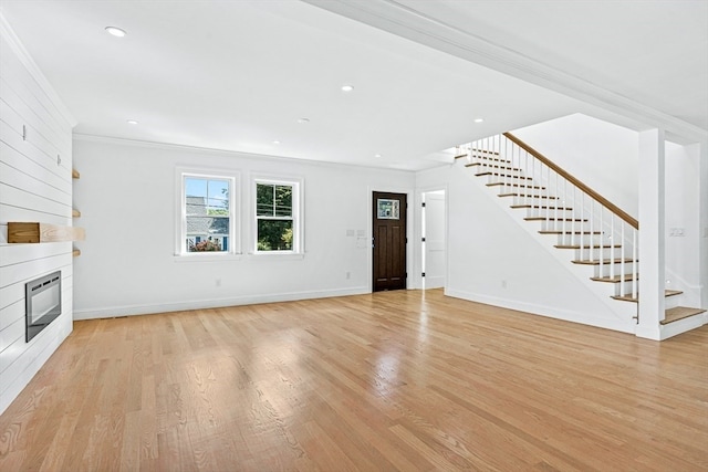 unfurnished living room featuring light wood-type flooring and crown molding