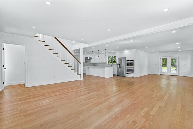 unfurnished living room with ornamental molding and light hardwood / wood-style floors