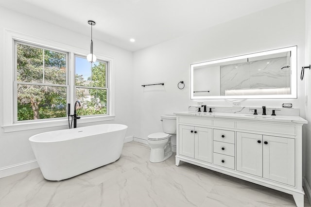 bathroom with a tub, vanity, toilet, and a healthy amount of sunlight