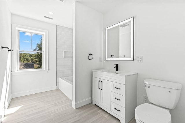 full bathroom featuring tiled shower / bath combo, vanity, toilet, and wood-type flooring