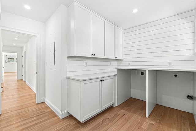 clothes washing area featuring hookup for an electric dryer, cabinets, and light hardwood / wood-style flooring