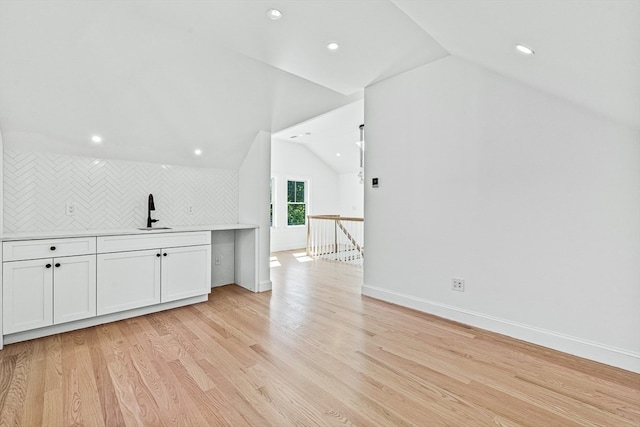 interior space with lofted ceiling, light hardwood / wood-style flooring, and sink