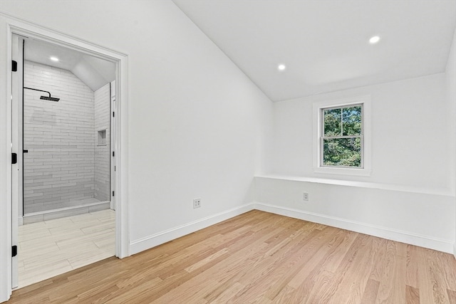 empty room featuring vaulted ceiling and light hardwood / wood-style floors