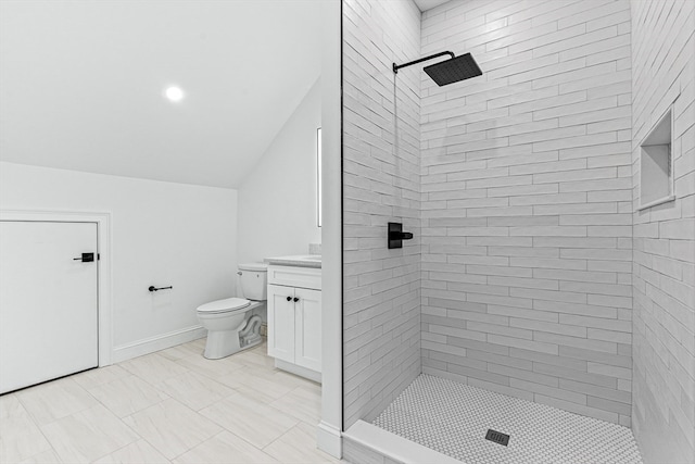 bathroom with lofted ceiling, toilet, a tile shower, and vanity