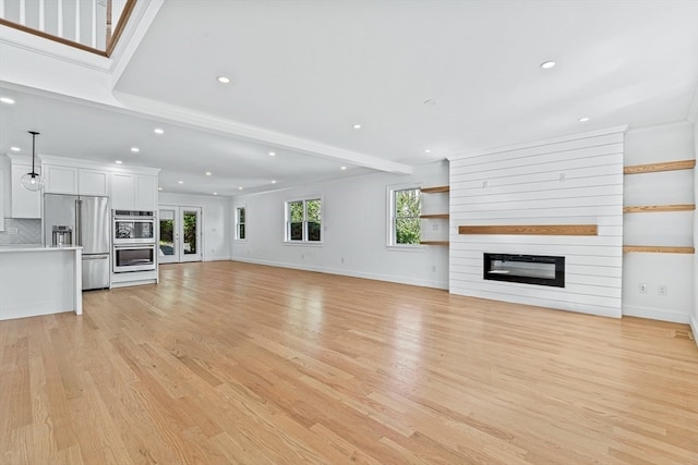 unfurnished living room with light hardwood / wood-style flooring and a large fireplace