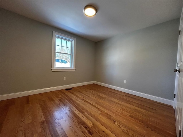 unfurnished room with wood-type flooring