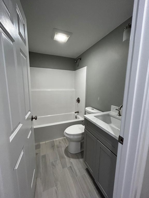 full bathroom featuring vanity, bathtub / shower combination, and toilet