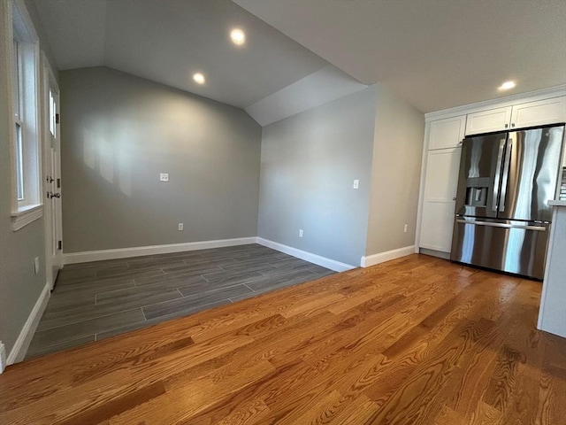 kitchen with dark hardwood / wood-style flooring, vaulted ceiling, white cabinets, and stainless steel refrigerator with ice dispenser