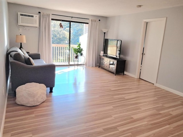300 Candlewood Park Unit 32, Nashua, NH 03062 - living area with light wood-type flooring, a wall mounted air conditioner, and baseboards
