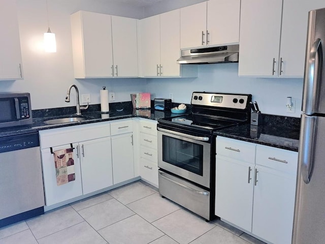 300 Candlewood Park Unit 32, Nashua, NH 03062 - kitchen with under cabinet range hood, stainless steel appliances, a sink, white cabinets, and dark stone countertops