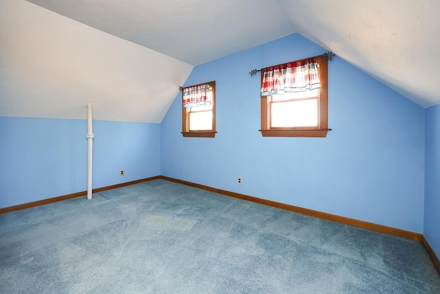 additional living space featuring lofted ceiling and carpet floors