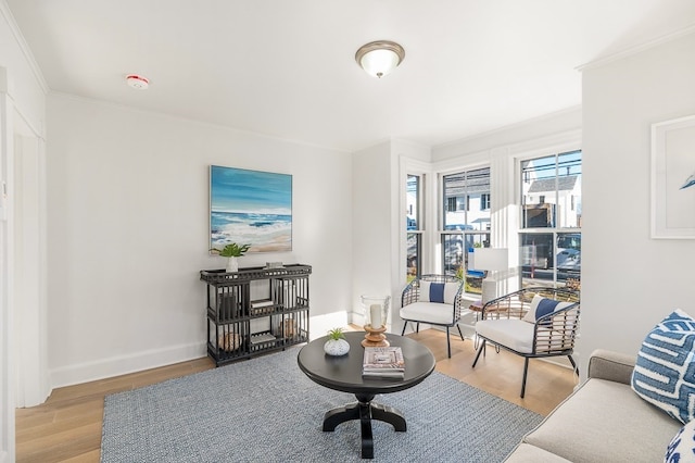 living room with crown molding and light hardwood / wood-style flooring